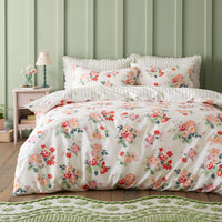 Floral bedding set on a bed with a green wall and nightstand in the background