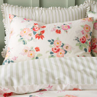 Floral and striped bedding set with ruffled edges on a green background