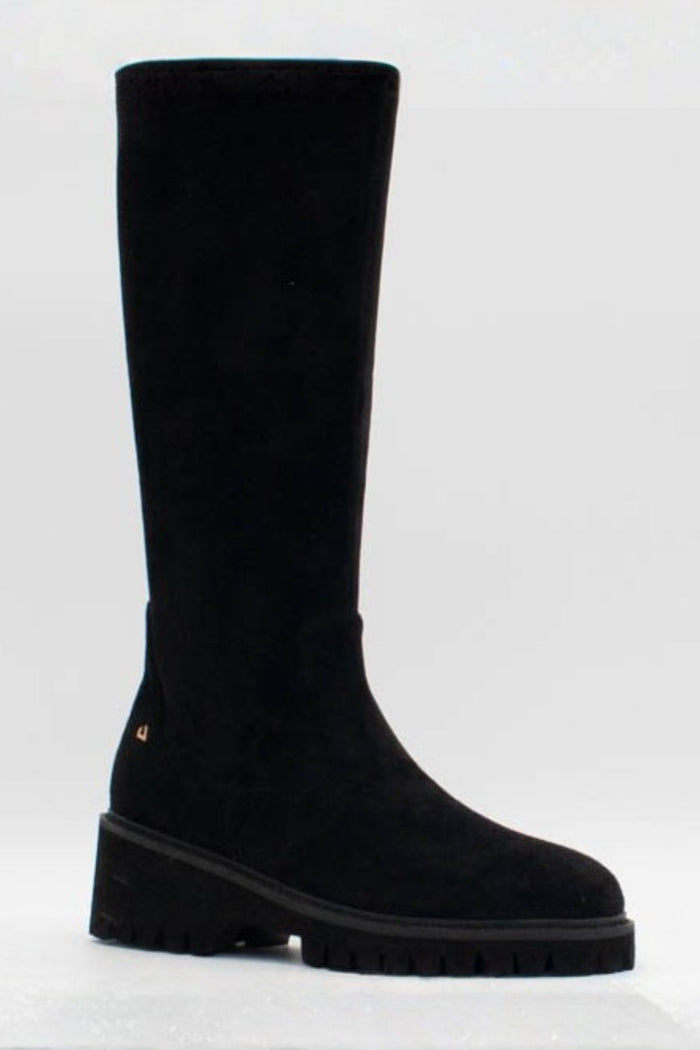 A single black suede knee-high boot with a chunky lug sole, shown from a side profile against a light gray background.