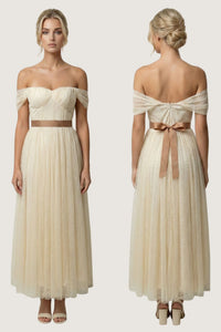 An off-the-shoulder cream maxi dress shown from both the front and back views on a model. The dress features a structured sweetheart bodice, a thin brown waistband, and a matching brown bow at the back of the waist.