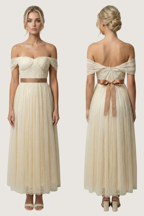 An off-the-shoulder cream maxi dress shown from both the front and back views on a model. The dress features a structured sweetheart bodice, a thin brown waistband, and a matching brown bow at the back of the waist.